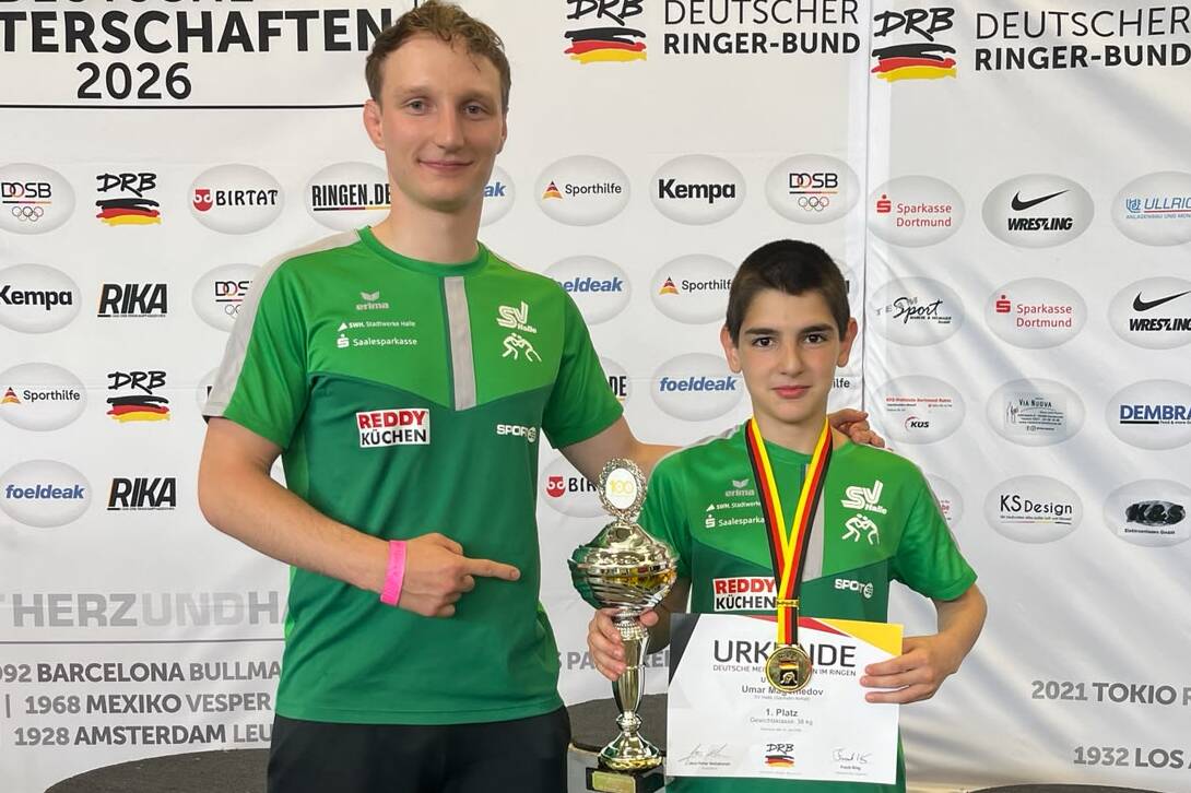 Umar Magamedov und Trainer Umar Magamedov und sein Trainer zeigen ihren Pokal und Medaille.