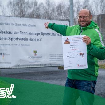 Hauptgeschäftsführer Ingo Michalak freut sich vor den neuen Tennisplätzen  über den Zuwendungsbescheid der Saalesparkasse